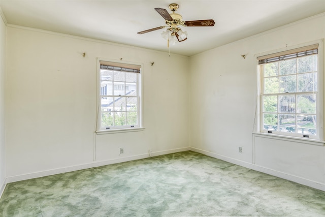 carpeted spare room featuring ceiling fan and crown molding