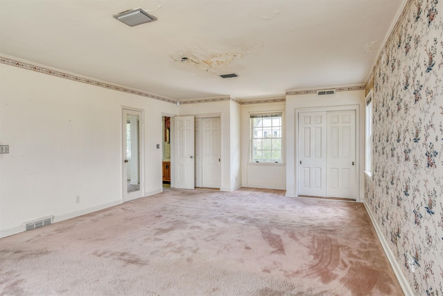 unfurnished bedroom with carpet floors and multiple closets