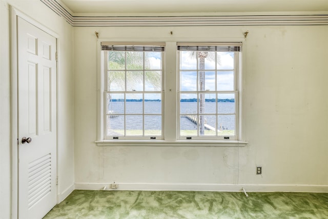 carpeted spare room featuring a water view