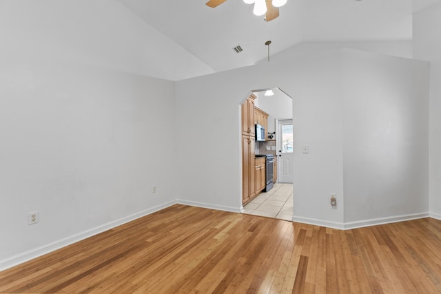 unfurnished room with ceiling fan, lofted ceiling, and light hardwood / wood-style flooring