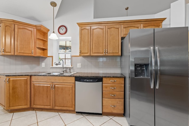 kitchen with sink, dark stone counters, lofted ceiling, and appliances with stainless steel finishes