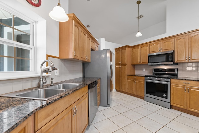 kitchen with sink, hanging light fixtures, light tile patterned floors, appliances with stainless steel finishes, and tasteful backsplash