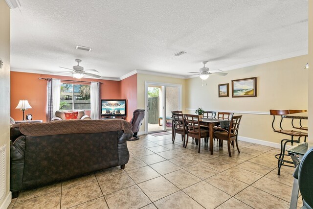 tiled living room with plenty of natural light, ceiling fan, and crown molding