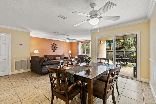 dining room featuring ceiling fan, ornamental molding, a textured ceiling, and light tile patterned floors