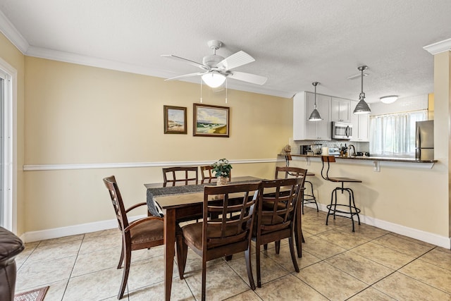 dining space with light tile patterned floors, a textured ceiling, ceiling fan, and crown molding