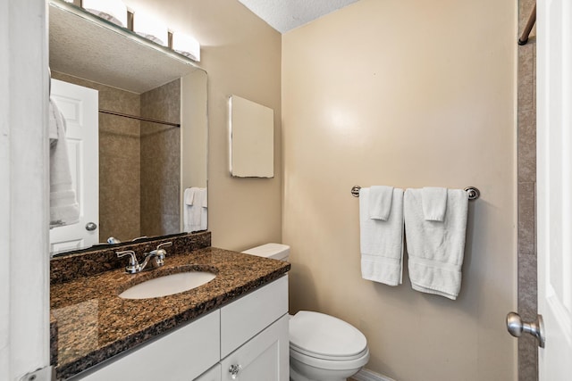 bathroom featuring vanity, toilet, and a textured ceiling