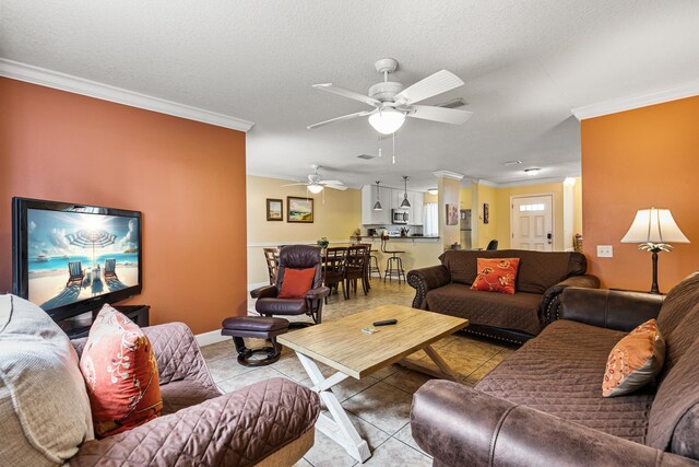 tiled living room with ceiling fan, a textured ceiling, and ornamental molding