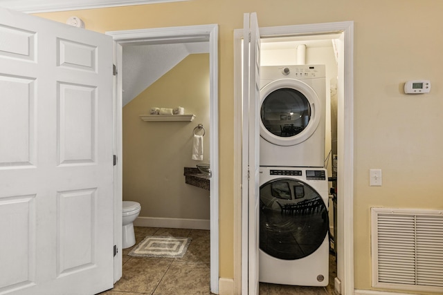 washroom featuring light tile patterned floors and stacked washer and dryer