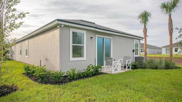 798 Grand Reserve Dr, Bunnell, FL 32110 - rear view of property featuring central AC unit, a yard, and stucco siding