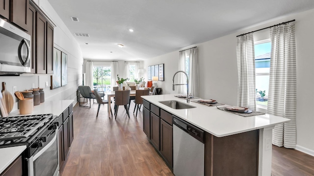 798 Grand Reserve Dr, Bunnell, FL 32110 - kitchen featuring appliances with stainless steel finishes, a sink, dark wood-style flooring, light countertops, and dark brown cabinetry