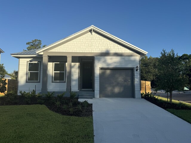 view of front of property featuring a garage and a front lawn