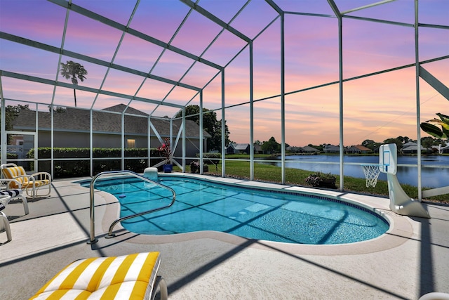 pool at dusk with a water view, glass enclosure, and a patio area