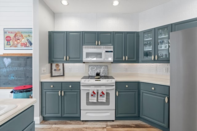 kitchen with white appliances and light hardwood / wood-style floors