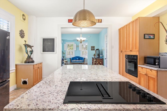 75 Osceola St, Saint Augustine, FL 32084 - kitchen featuring decorative light fixtures, a notable chandelier, black appliances, and light stone counters