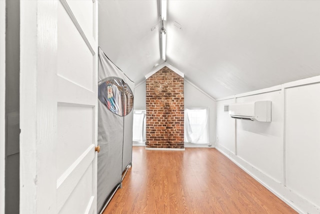 75 Osceola St, Saint Augustine, FL 32084 - bonus room featuring a wall mounted air conditioner, wood finished floors, vaulted ceiling, and brick wall