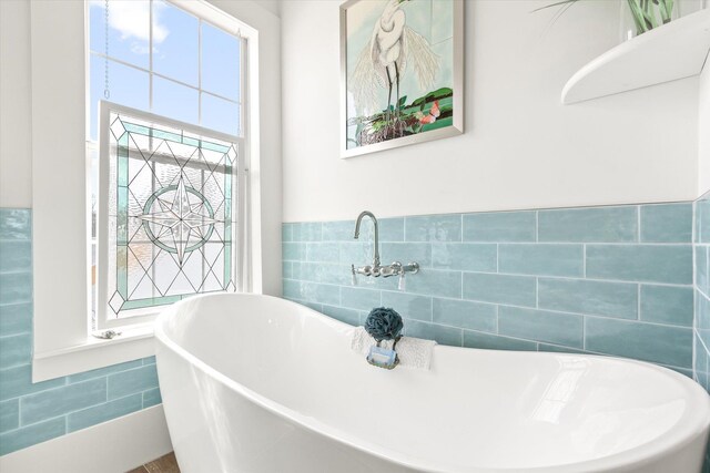 75 Osceola St, Saint Augustine, FL 32084 - bathroom featuring a freestanding tub, tile walls, and a wainscoted wall