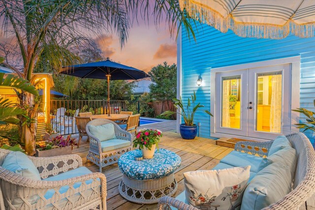 75 Osceola St, Saint Augustine, FL 32084 - deck at dusk featuring an outdoor living space, fence, and french doors