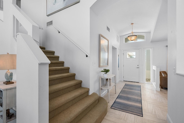 entrance foyer with stairway, baseboards, and visible vents