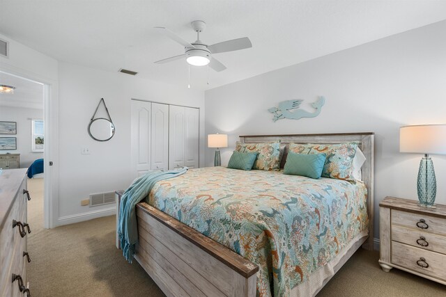 bedroom with a closet, light carpet, visible vents, and baseboards