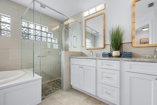 full bath featuring visible vents, a sink, a shower stall, and double vanity