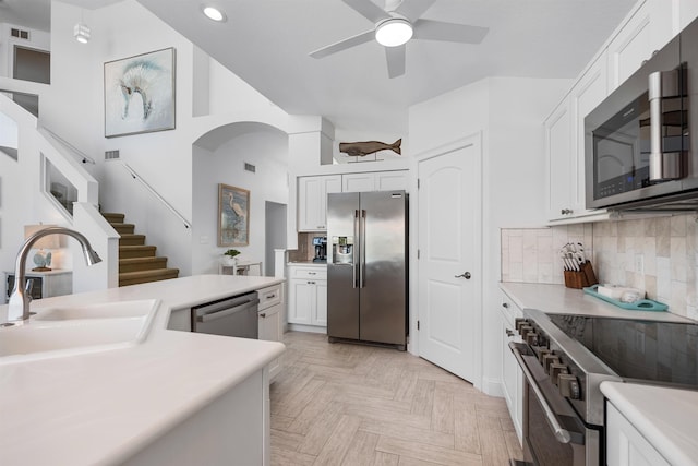 kitchen featuring light countertops, appliances with stainless steel finishes, a sink, and decorative backsplash