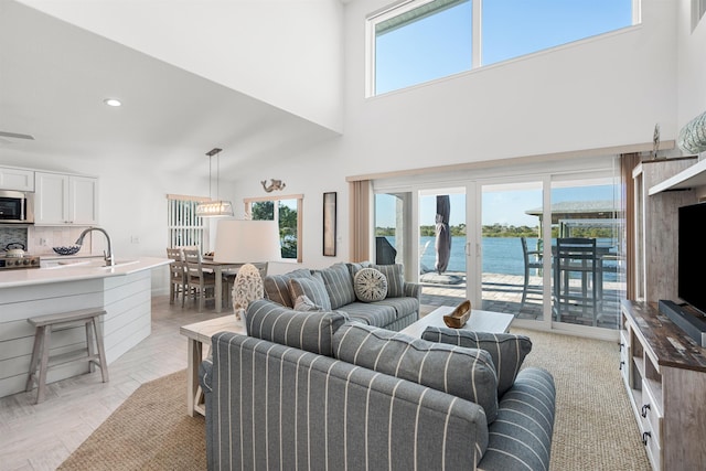 living area with a towering ceiling, a wealth of natural light, and recessed lighting