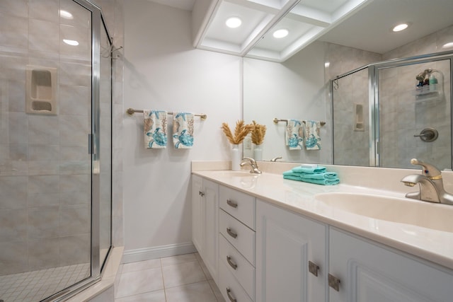 full bath featuring double vanity, a stall shower, a sink, and tile patterned floors