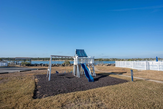 community playground featuring a water view and fence