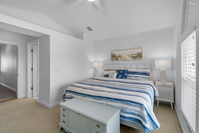 bedroom with visible vents, light carpet, vaulted ceiling, ceiling fan, and baseboards