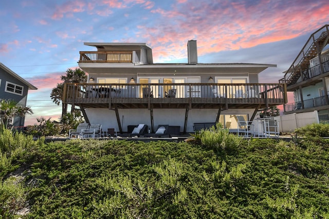 2749 S Ponte Vedra Blvd, Ponte Vedra Beach, FL 32082 - back of house at dusk featuring a chimney, stucco siding, and a deck