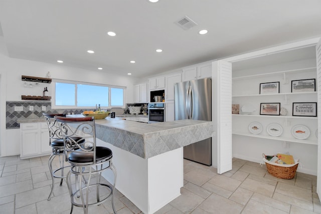 2749 S Ponte Vedra Blvd, Ponte Vedra Beach, FL 32082 - kitchen with appliances with stainless steel finishes, open shelves, a breakfast bar, white cabinetry, and recessed lighting