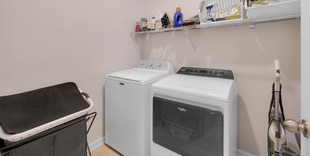 laundry room featuring laundry area, baseboards, and separate washer and dryer