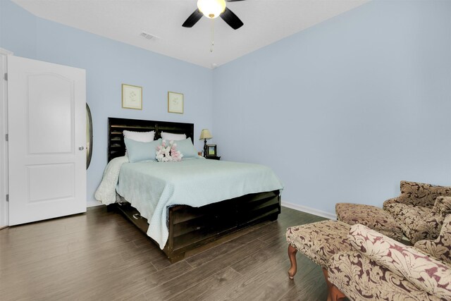 bedroom featuring multiple windows, baseboards, and dark wood-type flooring