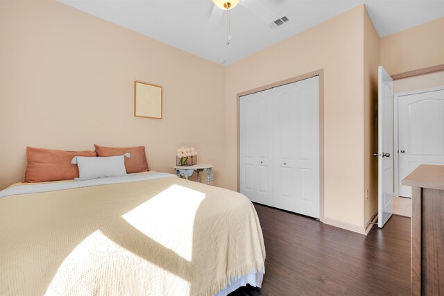 bedroom featuring dark wood-style floors, a closet, visible vents, and baseboards