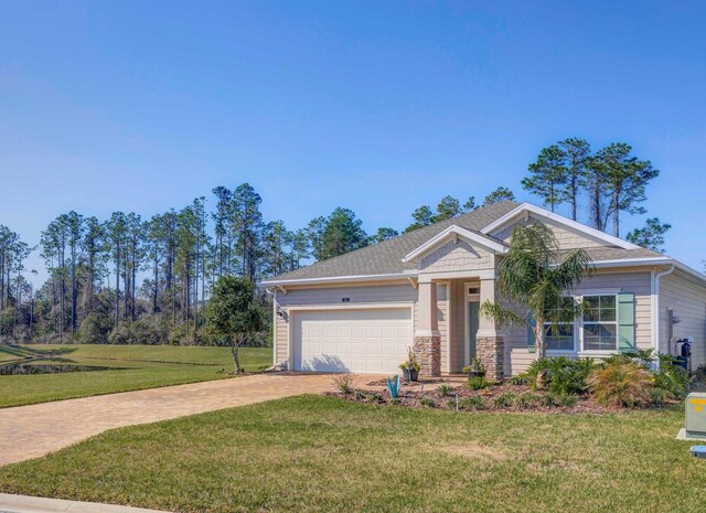 view of front of property with a garage, decorative driveway, stone siding, and a front lawn