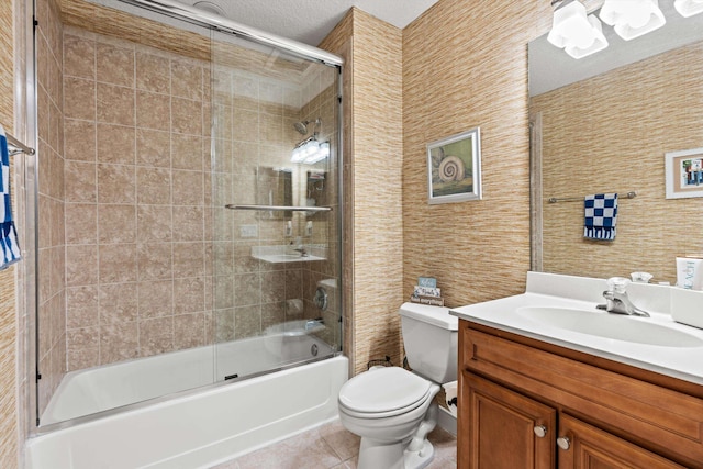 full bathroom featuring tile patterned flooring, a textured ceiling, toilet, shower / bath combination with glass door, and vanity