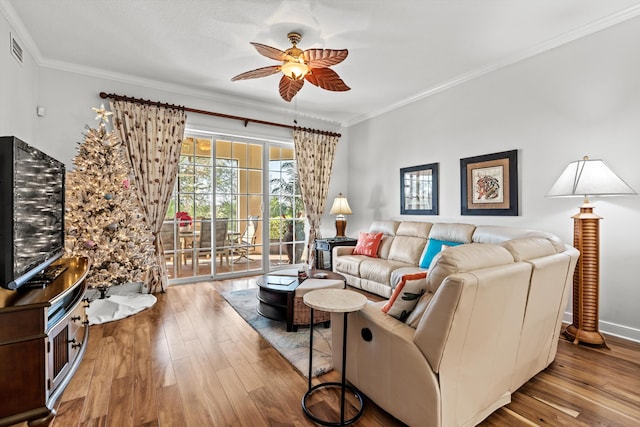 living room featuring ceiling fan, light wood-type flooring, and crown molding