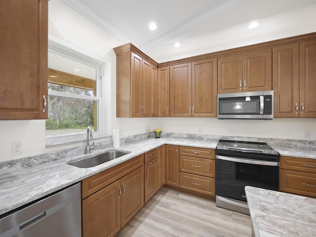 kitchen featuring light stone counters, sink, stainless steel appliances, and light wood-type flooring