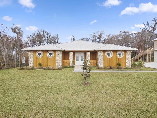 ranch-style home featuring a front yard and french doors