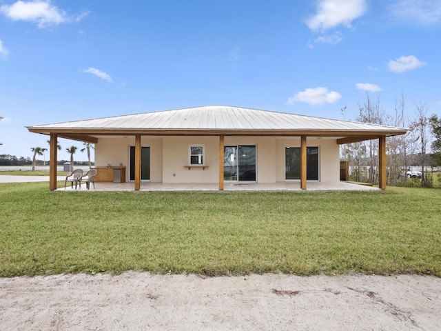 back of property with a yard and a patio area