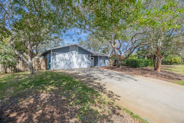 view of front of property with a front lawn, driveway, and fence