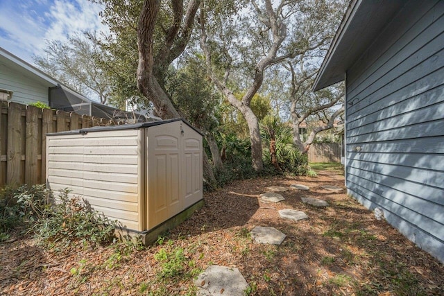 view of yard with an outbuilding, fence, and a shed