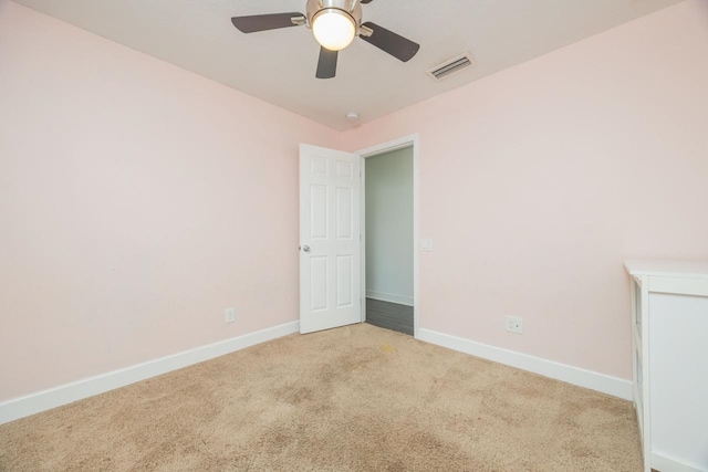 unfurnished room featuring visible vents, light carpet, baseboards, and ceiling fan