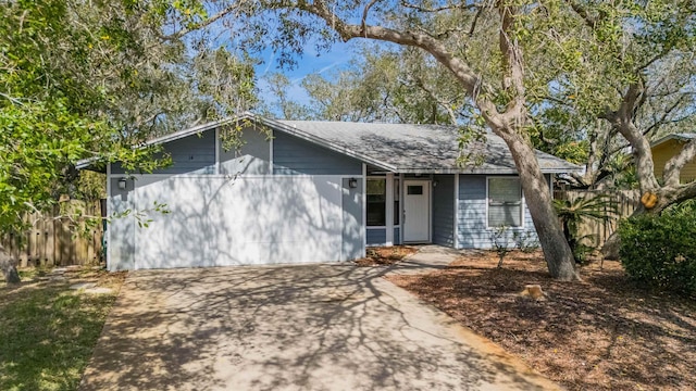 ranch-style home with concrete driveway and fence