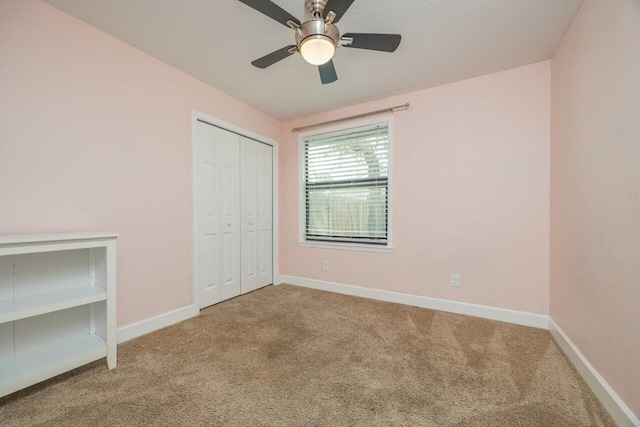 unfurnished bedroom with a closet, baseboards, carpet, and a ceiling fan