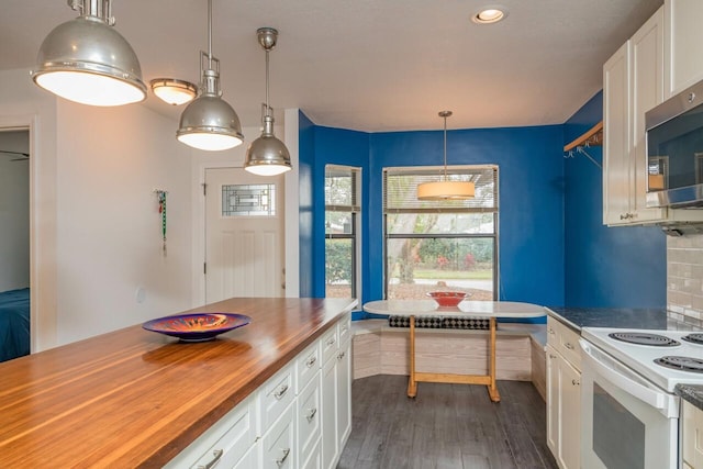 kitchen with stainless steel microwave, white cabinetry, breakfast area, white range with electric stovetop, and butcher block counters