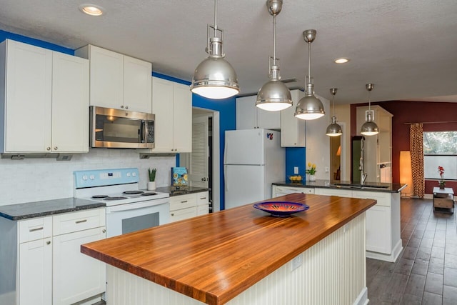 kitchen featuring a center island, butcher block countertops, decorative backsplash, dark wood-style floors, and white appliances