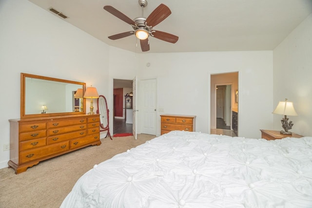 bedroom featuring visible vents, a ceiling fan, ensuite bath, carpet floors, and lofted ceiling