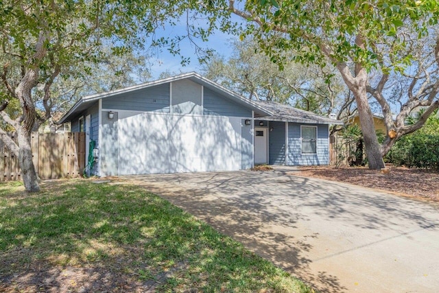 ranch-style house featuring fence and driveway