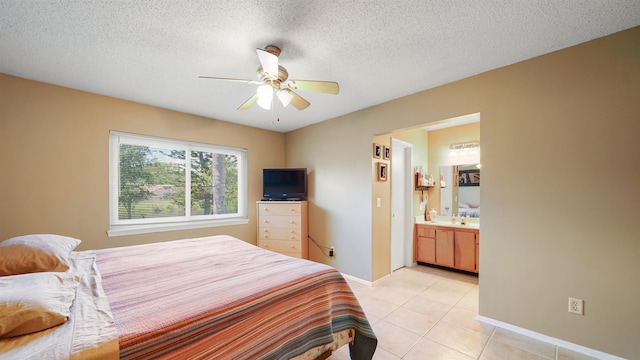 bedroom with ceiling fan, a textured ceiling, and ensuite bath